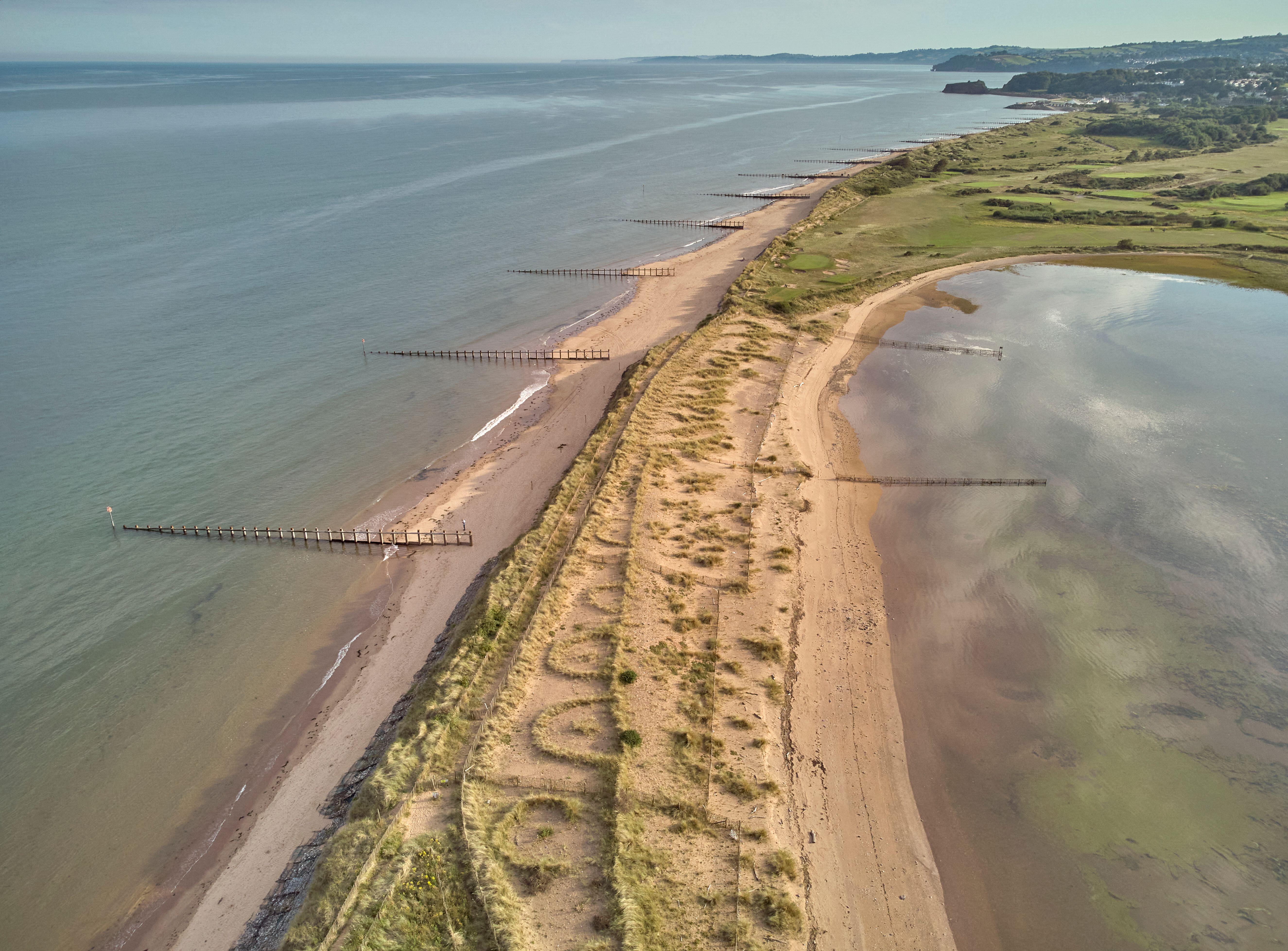 Aerial view of beach and dunes at Dawlish Warren, guarding the mouth of the River Exe, looking south along the coast towards the town of Dawlish
