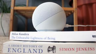 the amazon echo dot with clock pictured on a stack of books