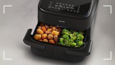 The Philips Series 100 Flexible Air Fryer cooking two types of vegetables in its drawer with the divider in place