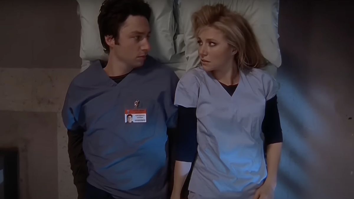 JD and Elliot laying next to each on hospital bed in Scrubs