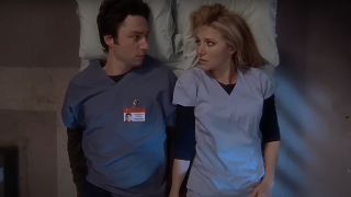 JD and Elliot laying next to each on hospital bed in Scrubs