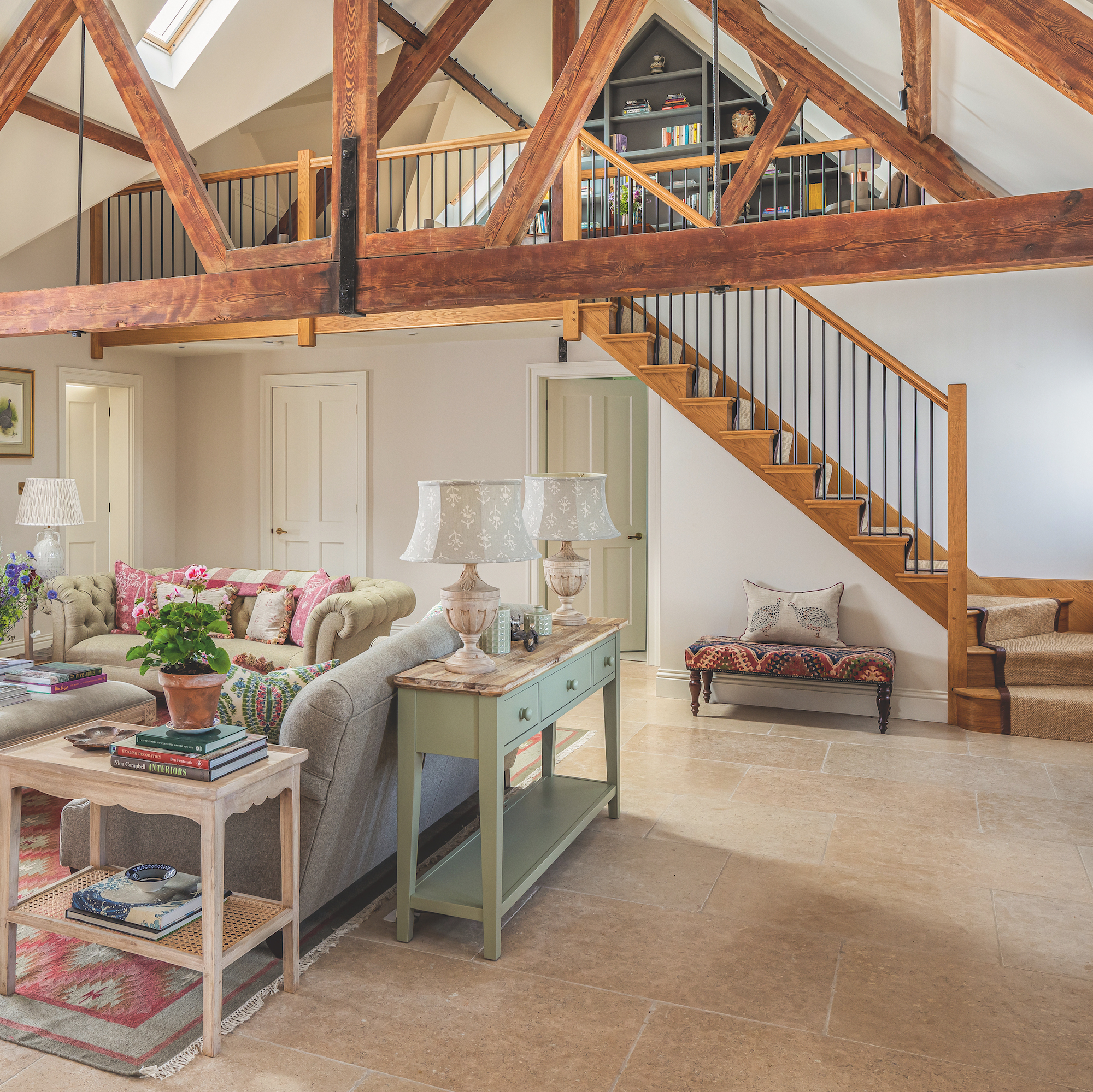converted barn with wooden staircase to mezzanine floor with seating area below