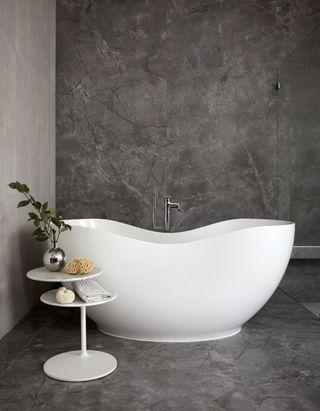 A freestanding bath with an accompanying side table