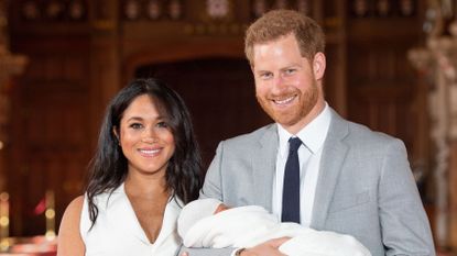 Britain's Prince Harry, Duke of Sussex (R), and his wife Meghan, Duchess of Sussex, pose for a photo with their newborn baby son, Archie Harrison Mountbatten-Windsor, in St George's Hall at Windsor Castle in Windsor, west of London on May 8, 2019