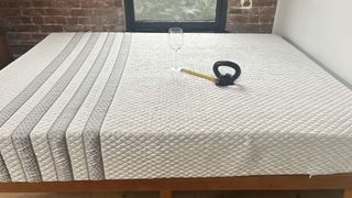 Leesa Sapira mattress with weight resting in the centre, next to wine glass