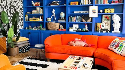 a bright orange sofa in a blue living room