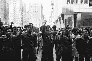 View of a line of Black Panther Party members as they demonstrate, fists raised outside the New York City courthouse, New York, New York, April 11, 1969.