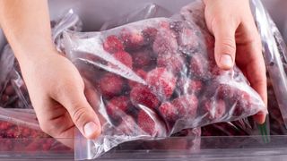 Hands holding a bag of frozen fruit berries