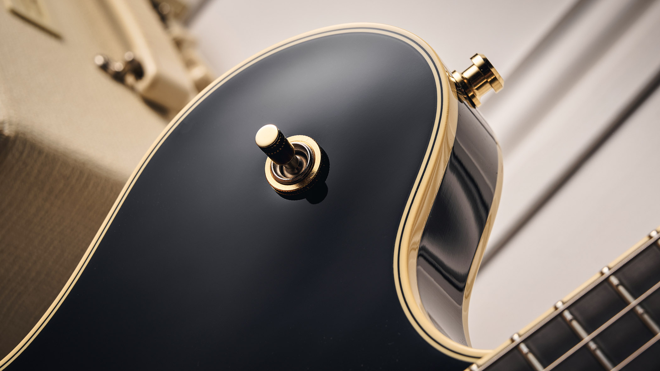 Gretsch Professional Collection Broadkaster LX Center Block: the handsome semi-hollow is finished in black with gold hardware and here is photographed in close-up.