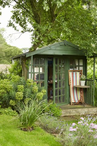 green summerhouse in garden