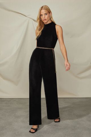 best party outfits - woman wearing high neck black velvet jumpsuit