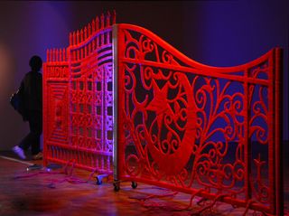 Two iron gates of different designs, covered with red string