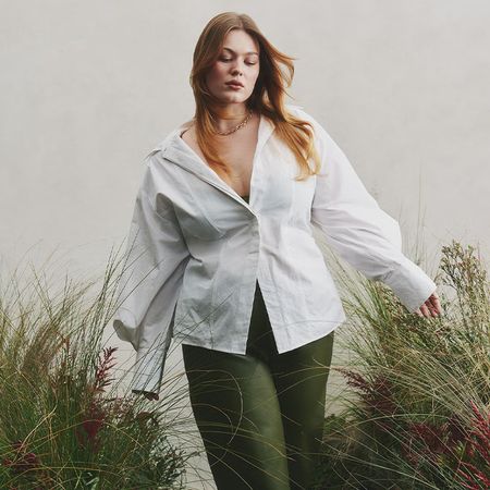 models wear white button down and green pants. Middle model wears pale blue high low dress. Furthest right model wears black pants and a drapey white top. 