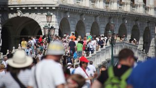 Summer scams news piece - crowded bridge in Venice