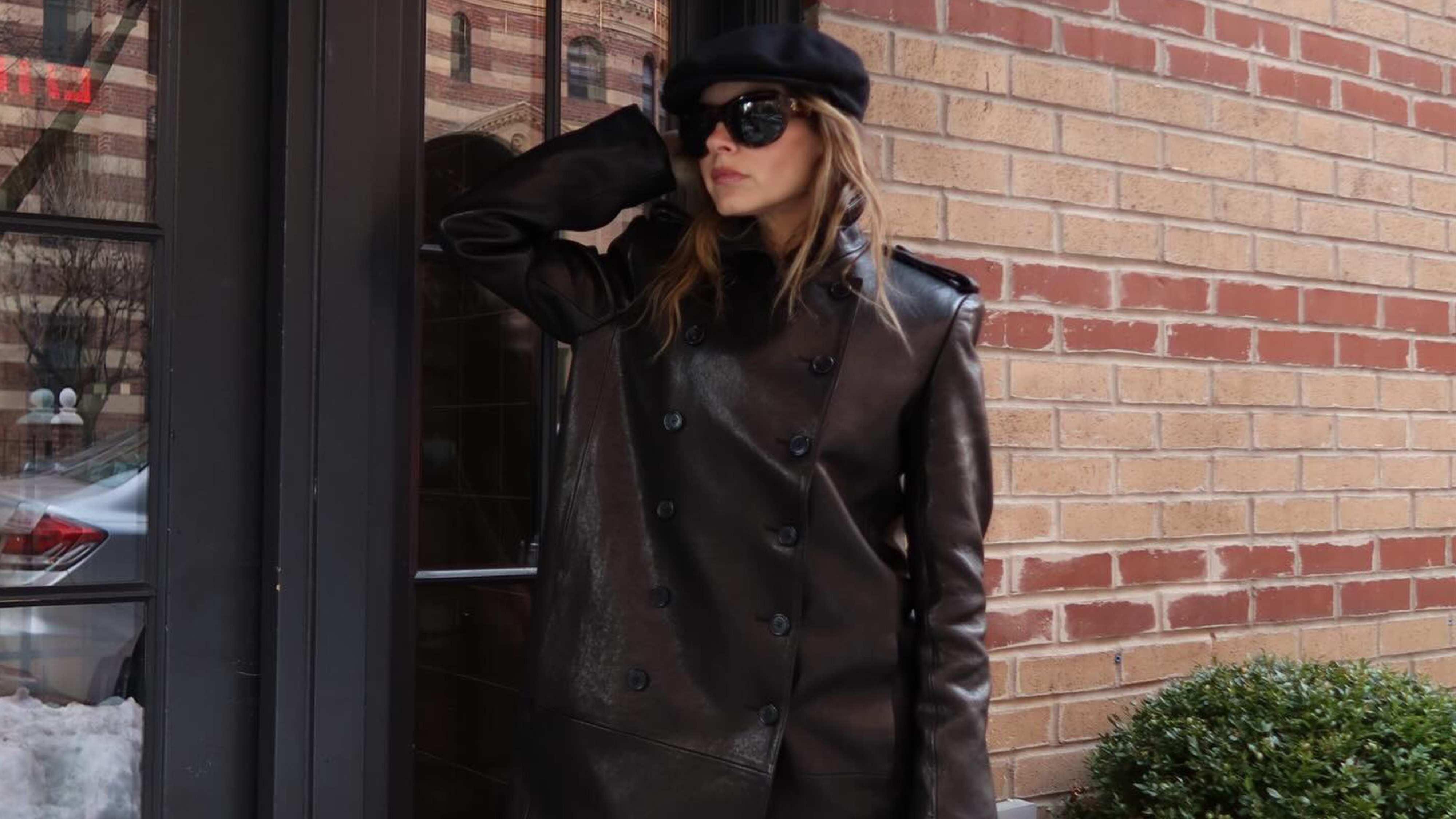 Nikki wears a leather jacket and a hat.