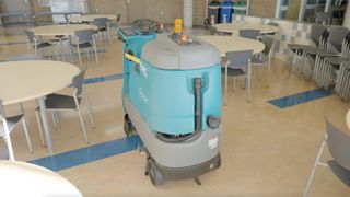 A robot cleaner cleans a cafeteria.