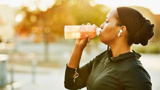 Women drinks juice as she takes a break from running