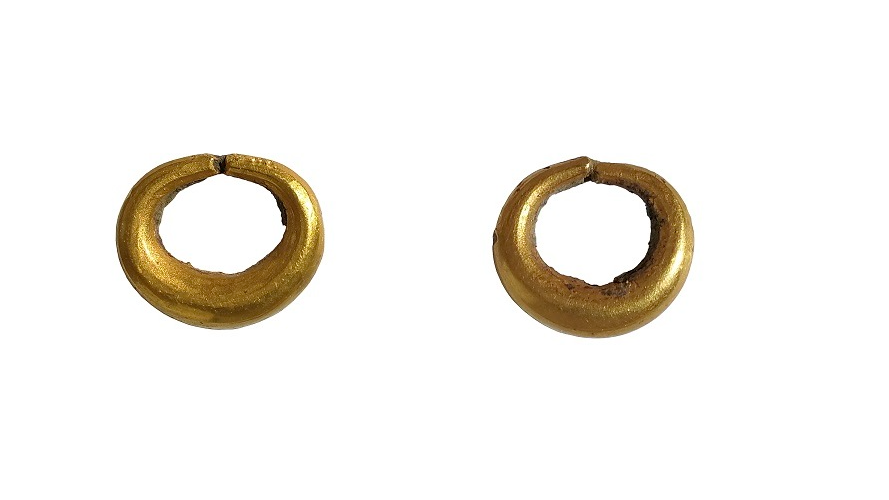 Two gold hoop earrings against a white background