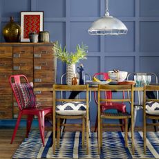 dining area with blue wall and drawer units and dining table with chair