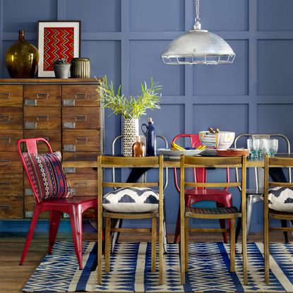 dining area with blue wall and drawer units and dining table with chair