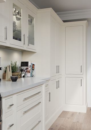 cream kitchen with stainless steel handles, floor to ceiling tall pantry cabinets