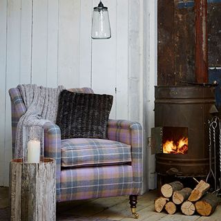 living room with wood burning stove and armchair with cushion
