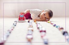 Young boy lining up toys