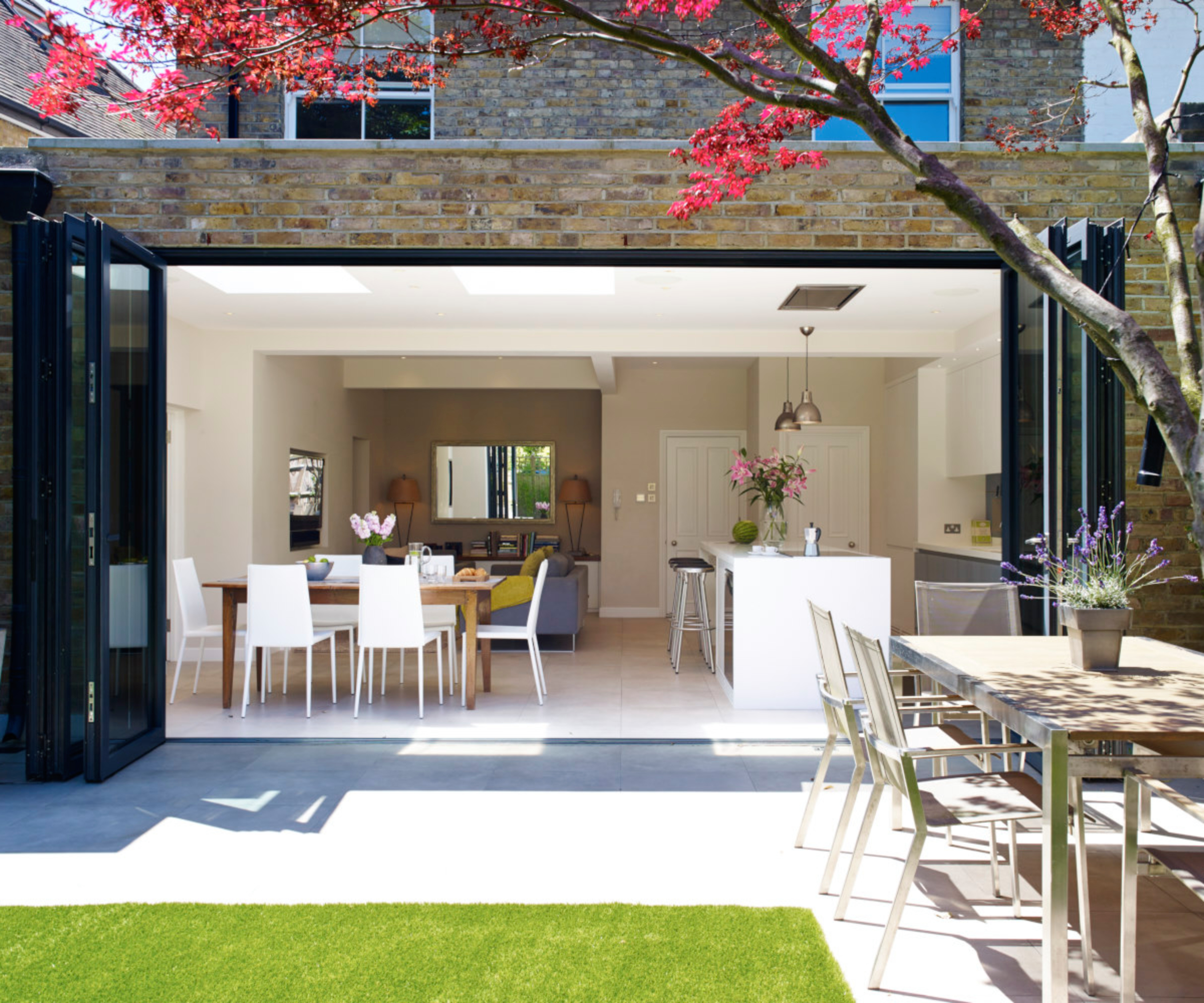 brick single storey small kitchen extension with bifold patio doors open showing kitchen and dining areas