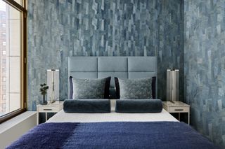 a guest bedroom with blue wallpaper