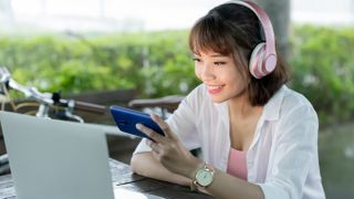 A person using a smartphone with headphones.