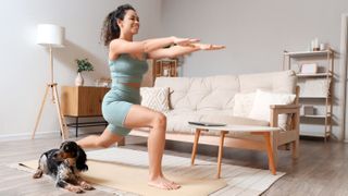 a woman working out on an exercise mat with her dog sat beside her
