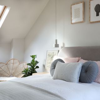 Loft bedroom with rooflight, upholstered heaboard and rattan peacock chair