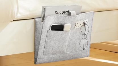 Bedside caddy in gray color hanging on side of bed