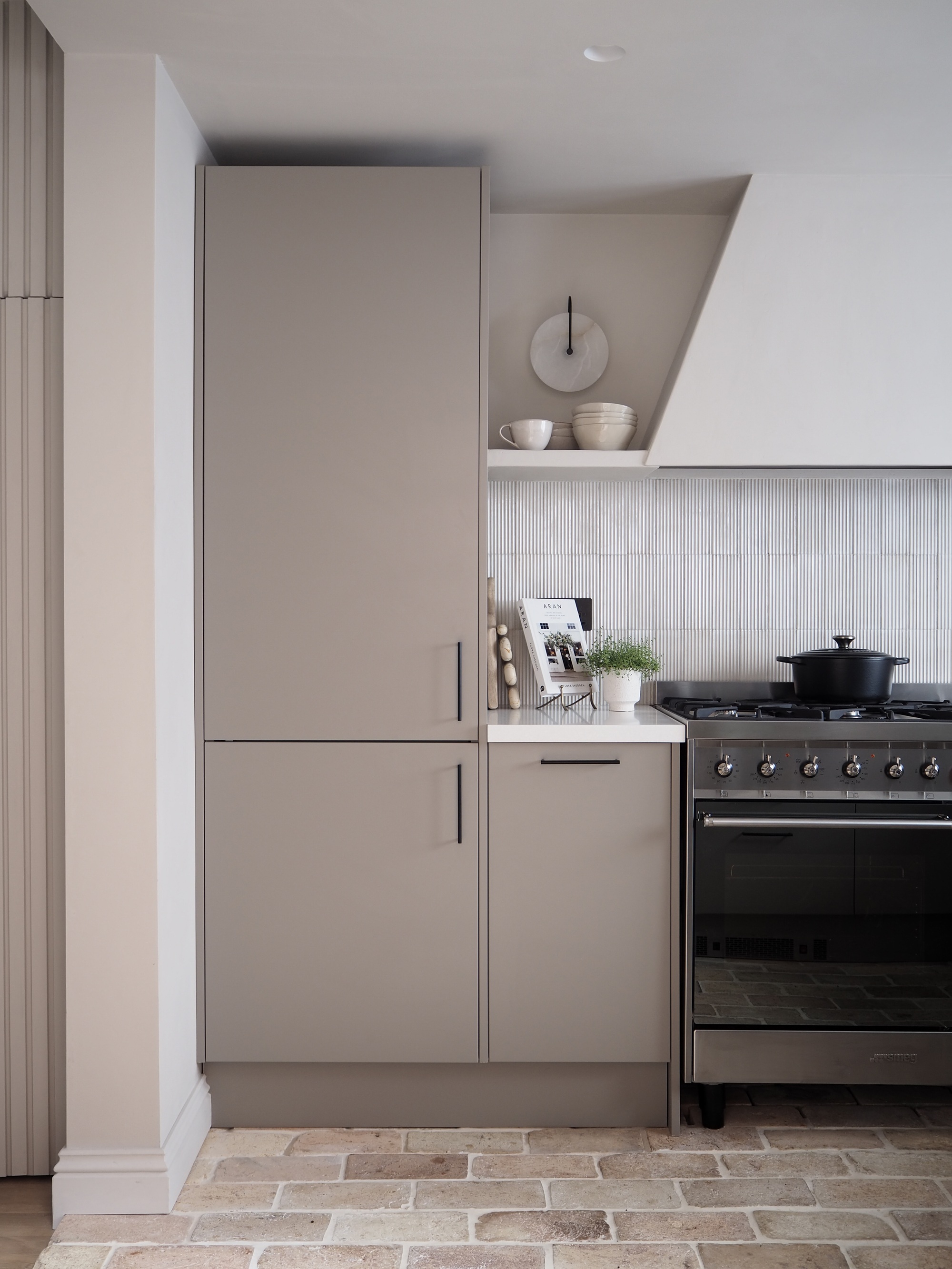 a kitchen with brown cabinets and a plastered in hood with a textured backsplash