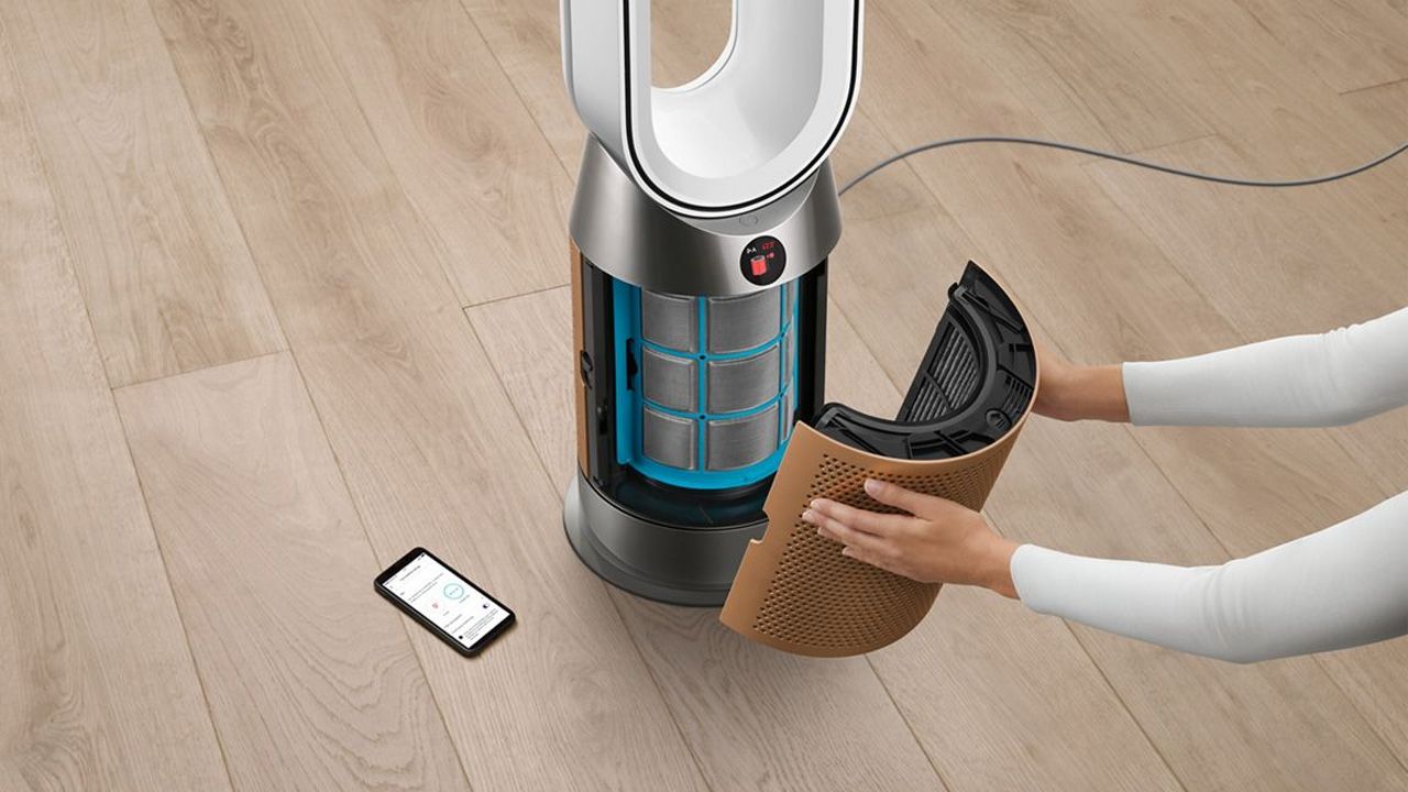 A pair of hands opening up the Dyson Purifier Hot+Cool Formaldehyde HP09 to replace the filter, removing the cover.