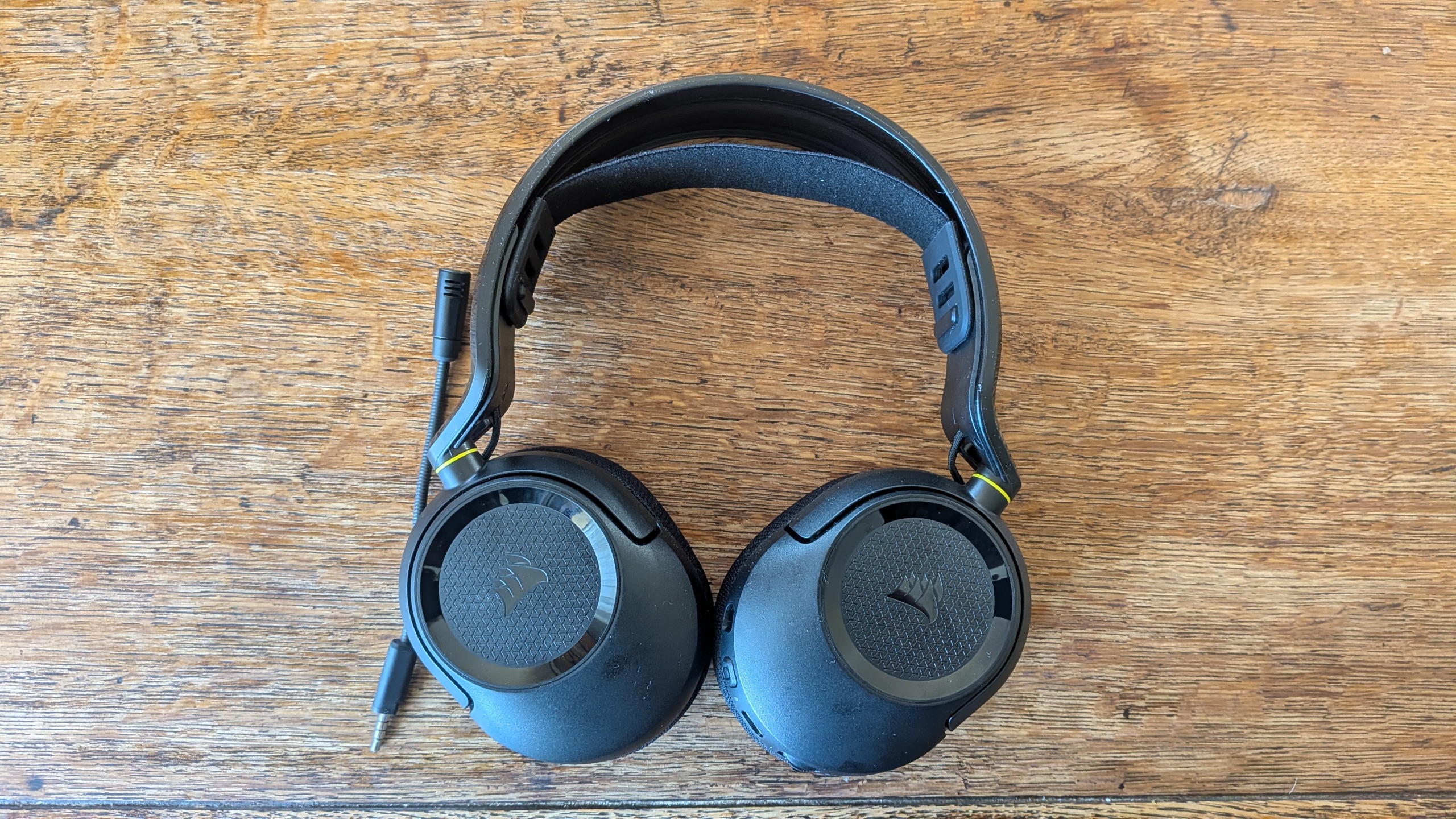 A gaming headset laid flat on a wooden surface