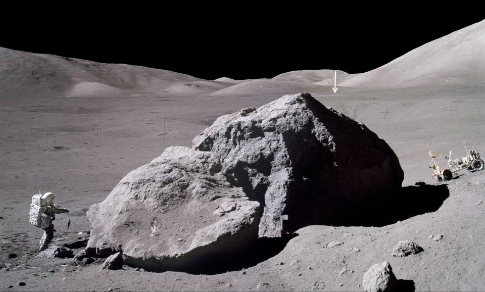 달에서 가장 오래 지속된 프로그램인 아폴로 17호의 표면 시간은 3일 2시간 59분이었습니다.  이 이미지는 아폴로 17호 우주선의 잭 슈미트(Jack Schmidt)가 거대한 바위의 동쪽을 관찰하고 샘플링한 후 달 모듈을 향해 전갈을 다시 운반하는 것을 보여줍니다.  거리의 수직 화살표는 약 2마일(3.1km) 떨어진 달 착륙선 챌린저를 가리킵니다.