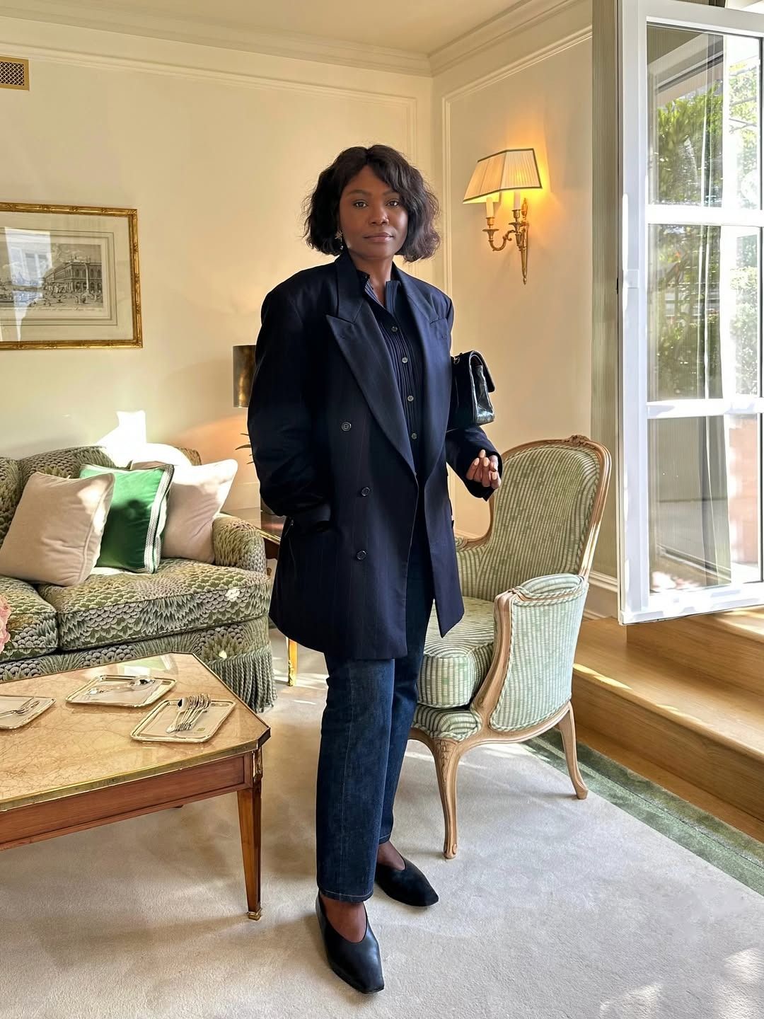 Woman in blazer and dark wash jeans.