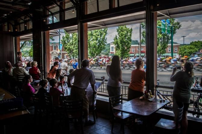 Fans watch from an open-air restaurant as the race goes past.
