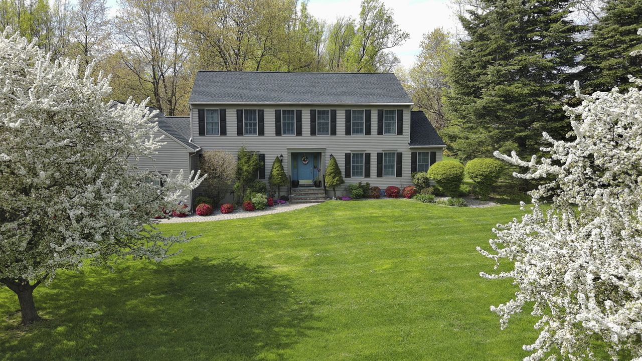 A lush, green front lawn outside a two-storey house