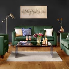 living room with grey wall green sofa with designed cushion wall frame and wooden flooring