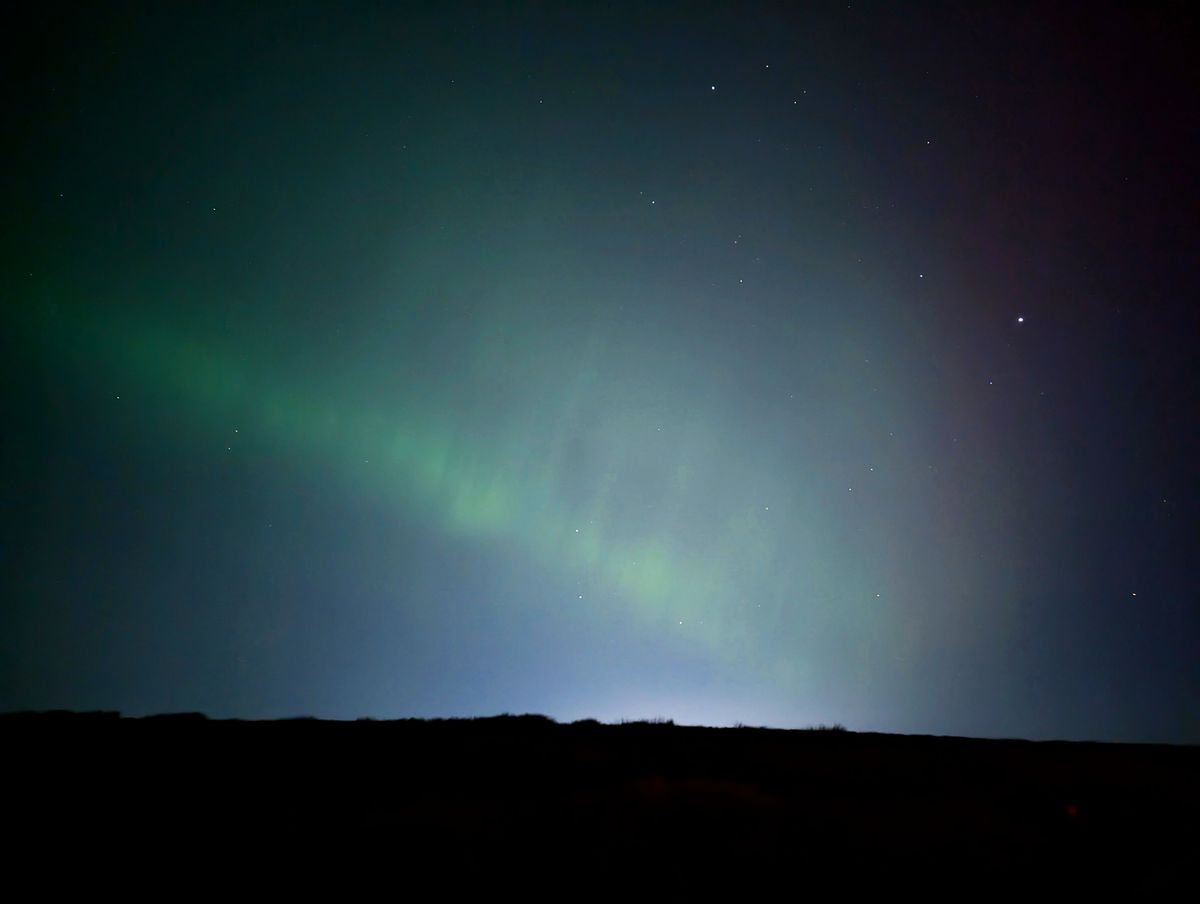 The Northern Lights' green pillars in the night sky