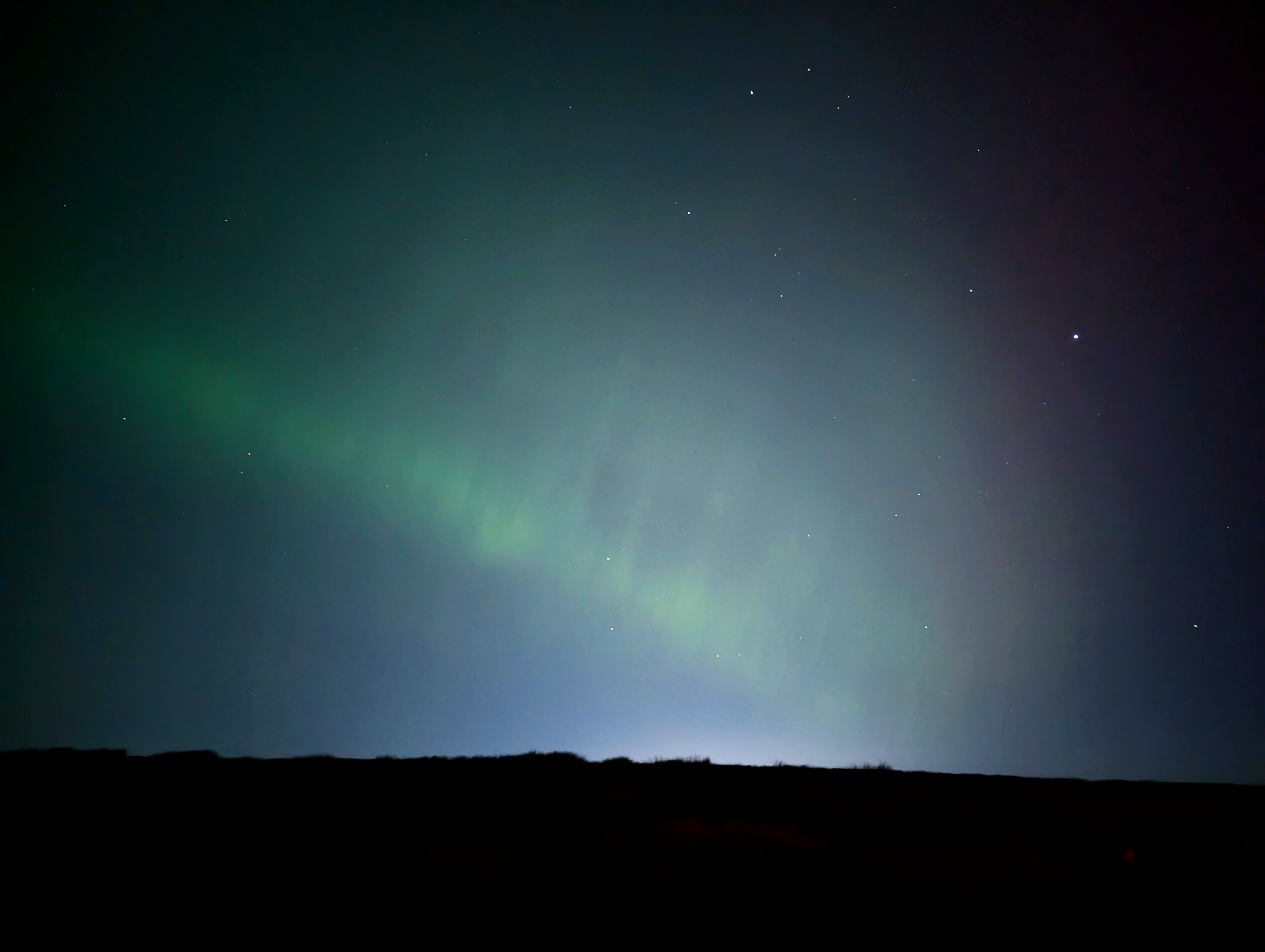 The Northern Lights' green pillars in the night sky