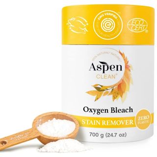 A yellow and white packet of Oxygen bleach stain remover with wooden spoon filled with powder