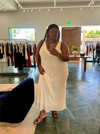 Chichi Offor wearing an off-white cowl-neck gown with red block-heel sandals from Reformation in the brand's Beverly Hills store.