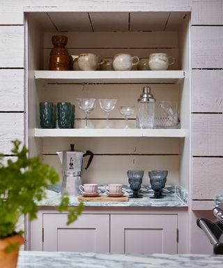 recessed shelving in a pink kitchen with panelled walls