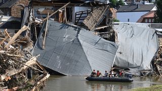 Military personnel float on a boat on the Ahr River in Rech, Germany, on July 21, after devastating floods hit the region.