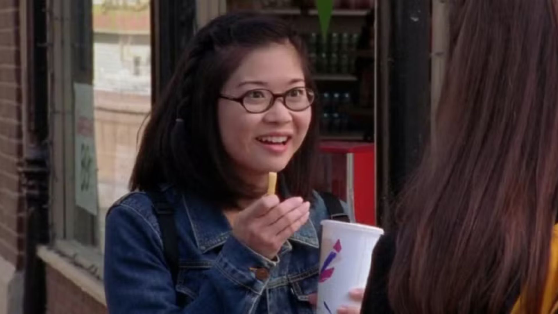 Lane Kim talks while holding a chip and a milkshake
