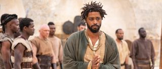 LaKeith Stanfield walking with his hands clasped together in The Book of Clarence.