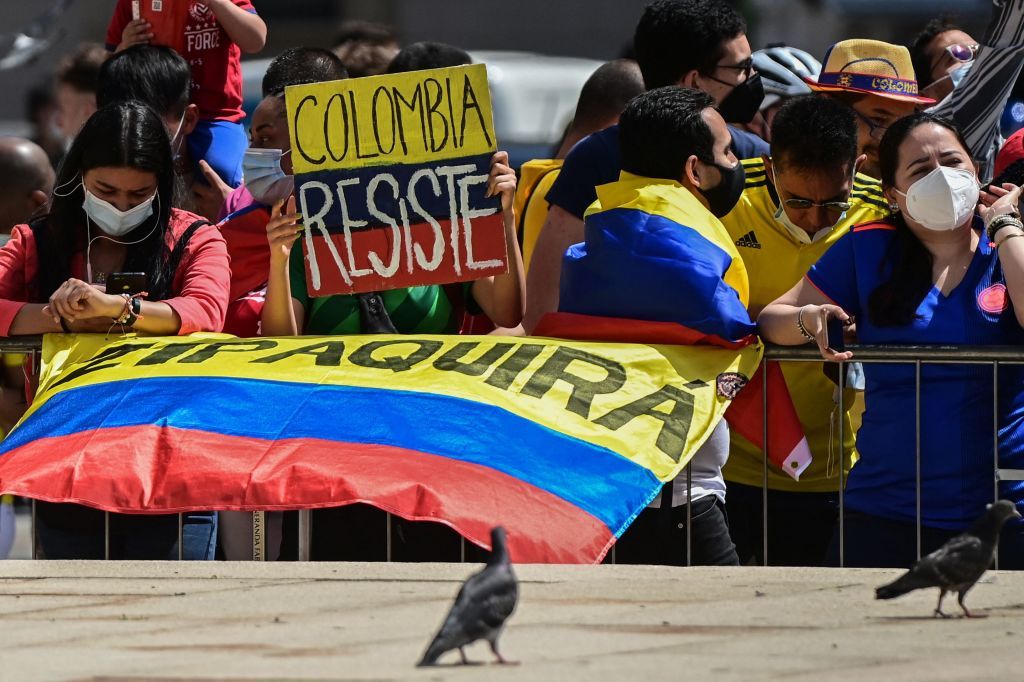 A woman with a group of Colombian fans holds a placard reading Colombia resists at the arrival spot on Piazza Duomo of the 21st and last stage of the Giro dItalia 2021 cycling race a 303km individual time trial between Senago and Milan on May 30 2021 Photo by MIGUEL MEDINA AFP Photo by MIGUEL MEDINAAFP via Getty Images
